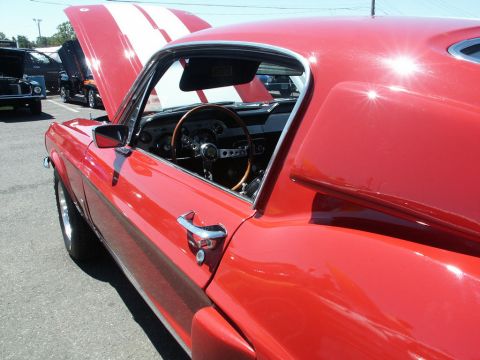 2001 Mercury Grand Marquis - A bright red classic car with white racing stripes on the hood is displayed with its door and hood open, revealing the interior.