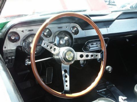 2001 Mercury Grand Marquis - Interior view of a 1967 Ford Mustang, a wood-rimmed steering wheel and original radio.