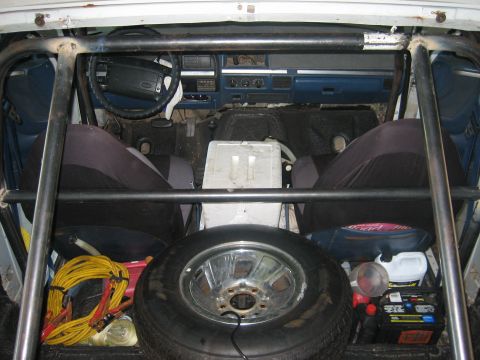 1994 Ford Bronco - Interior view of a 1994 Ford Bronco, modified with a roll cage and spare tire.