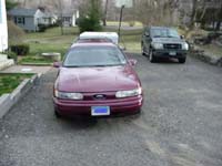 1993 Ford Taurus - A maroon 1992 Ford Taurus is parked in a gravel driveway with another vehicle behind it.