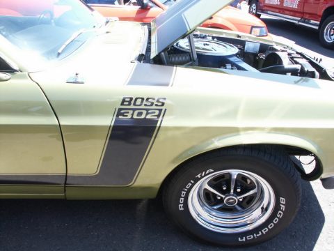 2001 Mercury Grand Marquis - A gold 1969 Ford Mustang Boss 302 is displayed with its hood open, revealing the engine compartment.