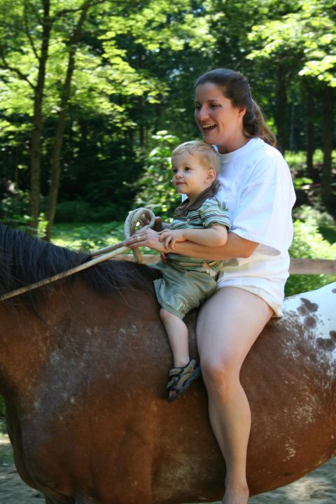 1966 Land Rover Discovery - A woman and child ride a horse through a wooded area.