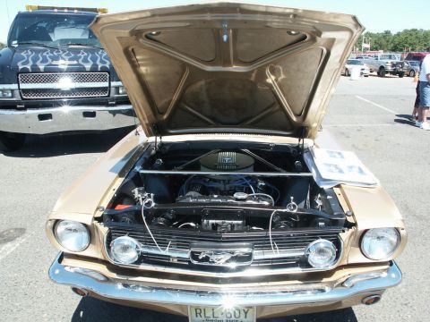 2001 Mercury Grand Marquis - 1965 Ford Mustang at a car show, with a black truck behind it.