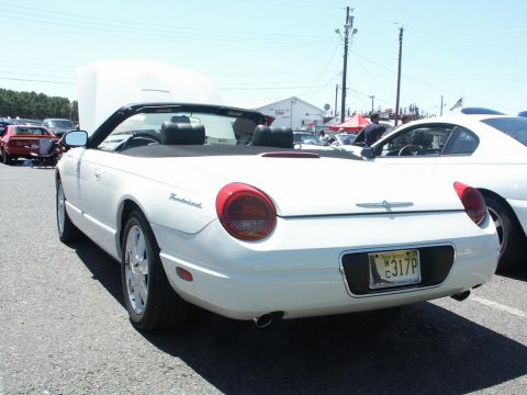2001 Mercury Grand Marquis - A white convertible is parked at an outdoor event with its hood open, showing the interior and rear of the vehicle.