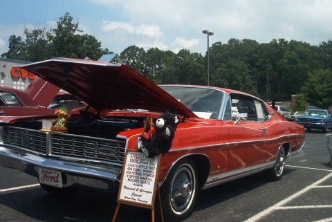 1985 Ford Crown Victoria LTD - A red 1968 Ford XL coupe is displayed with its hood open, alongside other vehicles.