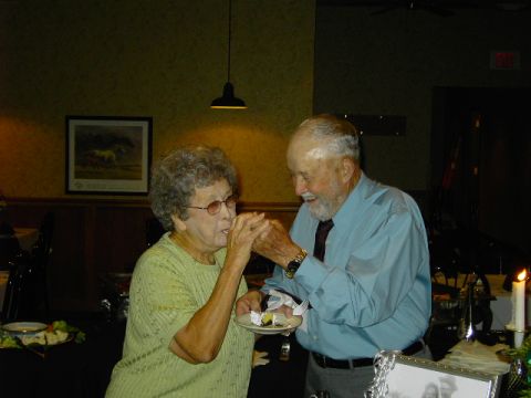 1991 Ford Bronco - An elderly couple shares a moment while feeding each other cake at a celebration.