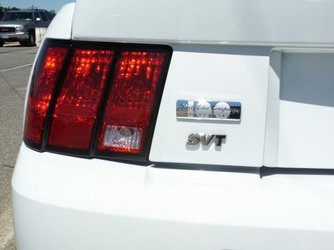 2001 Mercury Grand Marquis - The rear of a white car displays an SVT badge and a Ford Motor Company Centennia badge, indicating it is not a 2001 Mercury Grand Marquis.