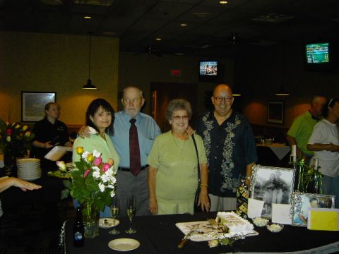 1991 Ford Bronco - A group of people pose for a photo at a table decorated with a cake, flowers, and framed pictures, vintage pictures.