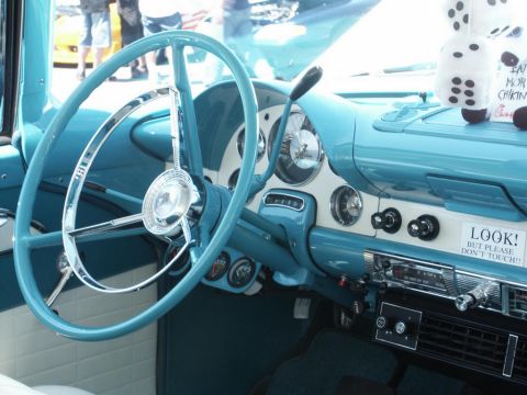 2001 Mercury Grand Marquis - The interior of a vintage car features a distinctive steering wheel and dashboard with a humorous warning sticker.