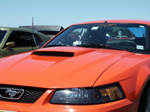 2001 Mercury Grand Marquis - Front view of an orange Ford Mustang, a prominent hood scoop and the iconic pony emblem on the grille.