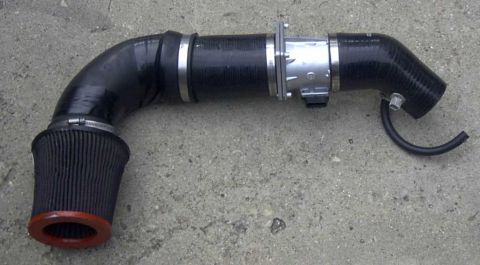 1997 Ford Taurus - Aftermarket intake system a black cone filter and metal housing, likely for performance enhancement.
