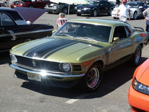 2001 Mercury Grand Marquis - A classic green 1970 Ford Mustang Boss 302 is parked at a car show with other vehicles.