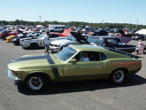 2001 Mercury Grand Marquis - A gold 1970 Ford Mustang Boss 302 is parked at a car show with other vehicles.