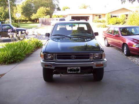 1995 Toyota Hilux - A dark green 1995 Toyota Hilux pickup truck is parked in a driveway.