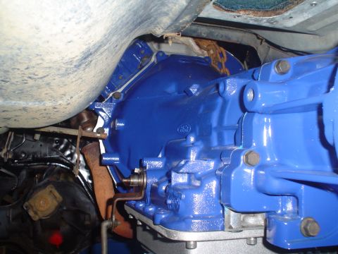 1984 Ford Bronco - Close-up view of a freshly painted blue transmission and drivetrain components, showing mechanical details.