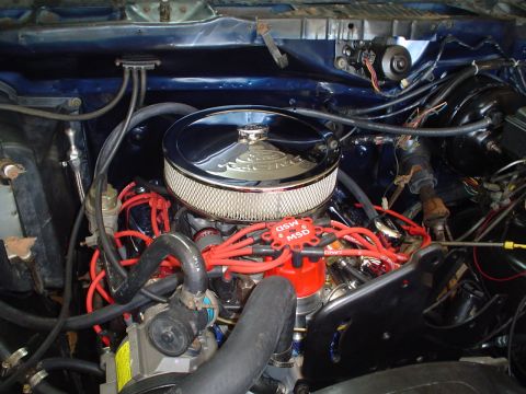 1984 Ford Bronco - Close-up view of a vehicle's engine bay, a chrome air filter and red spark plug wires.