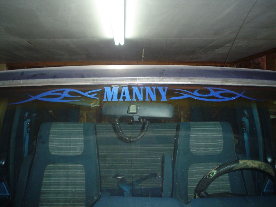 Vehicle interior with blue tribal graphics and "MANNY" text on the rear window