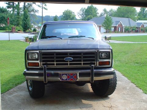 1984 Ford Bronco - This 1980s Ford Bronco is seen from the front, a prominent grille and a distinctive license plate frame.