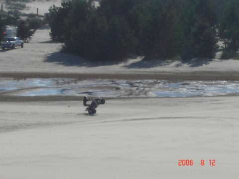 1993 Ford Bronco - An ATV is seen on its side in the sand dunes, with a pickup truck and trailer in the background.