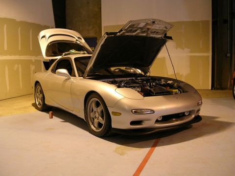 1996 Ford Probe - This silver Mazda RX-7 has its hood and trunk open, revealing the engine compartment and rear storage area.
