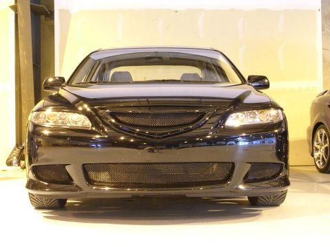 1996 Ford Probe - The front of a black sedan is shown, a custom grille and bumper.
