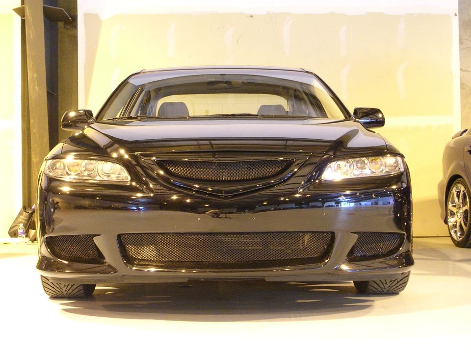 front view of a black sedan with custom grille and bumper