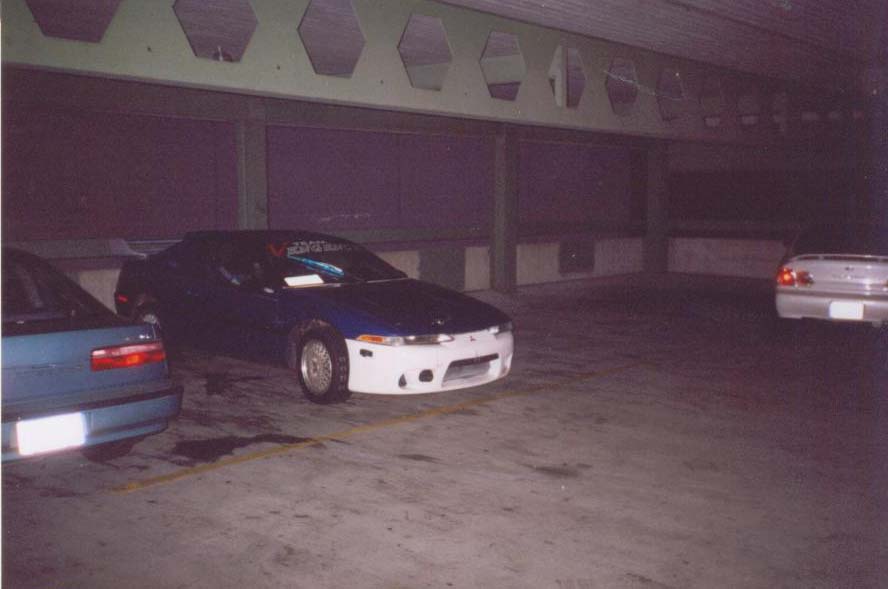 Blue car and a dark colored car parked in a garage