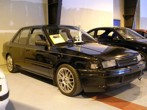 1996 Ford Probe - This black sedan, likely from the early 1990s, is parked indoors with another vehicle visible behind it.