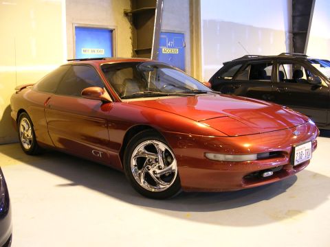 1996 Ford Probe - A red 1996 Ford Probe GT is parked in a garage next to a black SUV.