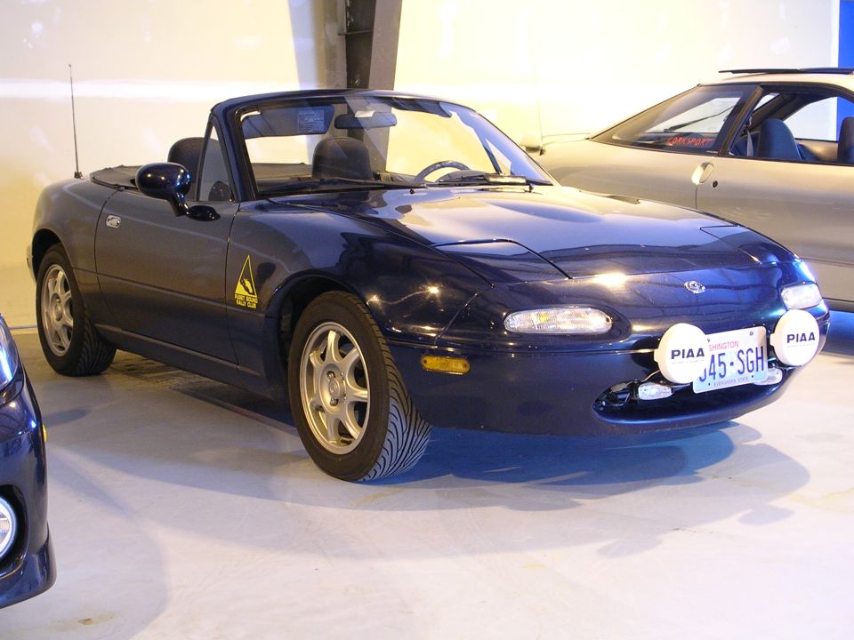 Dark blue convertible with pop-up headlights and PIAA driving lights