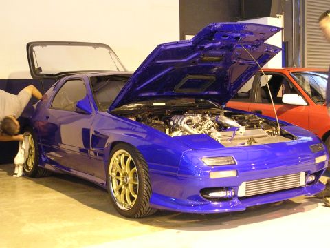 1996 Ford Probe - A blue sports car with its hood open is parked next to a red car.