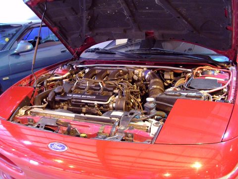 1996 Ford Probe - Engine bay of a red 1996 Ford Probe, its V6 DOHC 24-valve engine and Ford badging.
