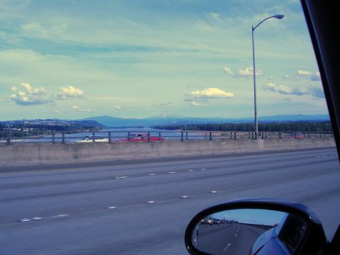 1996 Ford Probe - Driving across a bridge with a scenic view of a river and mountains in the distance.