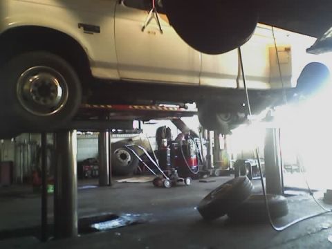 1992 Ford Bronco - White 1992 Ford Bronco undergoing service on a lift in a repair shop.