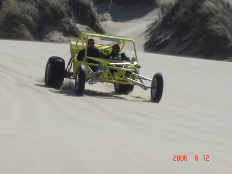 1993 Ford Bronco - A dune buggy navigates sandy terrain with two occupants.