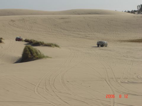 1993 Ford Bronco - Vehicles navigate the sandy terrain of the dunes, leaving tracks behind.