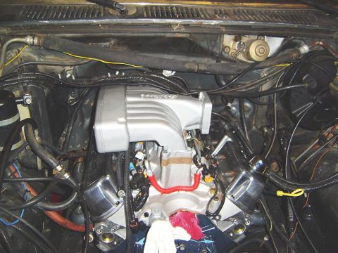 1986 Ford Bronco - Aftermarket intake manifold installed in an engine bay, likely part of an engine swap or upgrade.