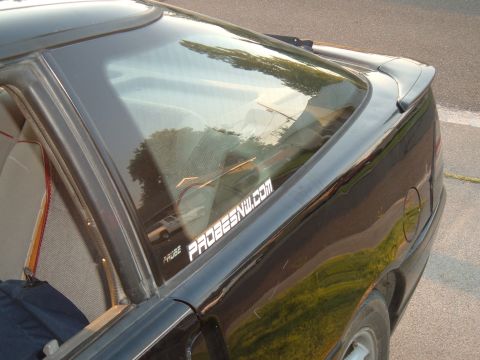 1991 Ford Probe - A sticker on the rear window of a black car reads "PROBESNW.COM" and "PROBE".