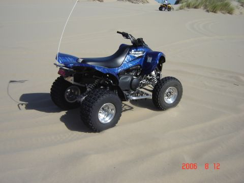 1993 Ford Bronco - A blue Kawasaki ATV is parked on a sandy dune with another ATV visible in the background.