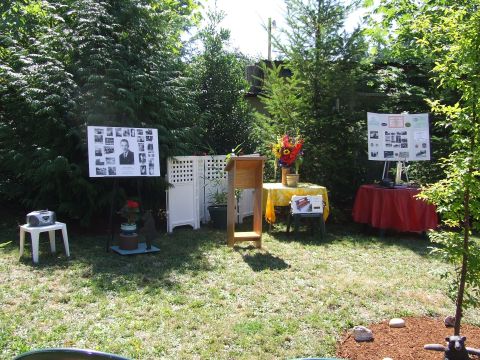 1976 Ford F-150 - An outdoor memorial event is set up with displays and a podium in a grassy yard.