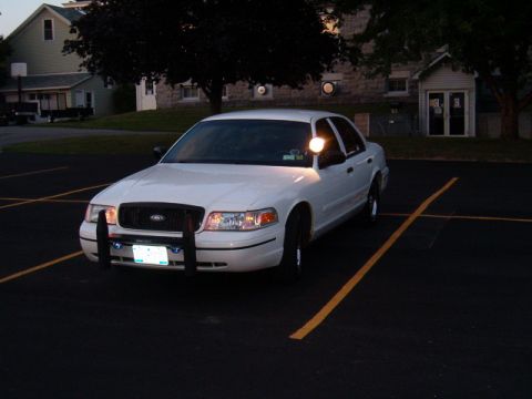 1999 Ford Crown Victoria - This 1999 Ford Crown Victoria police car is equipped with a push bumper and parked in a lot.