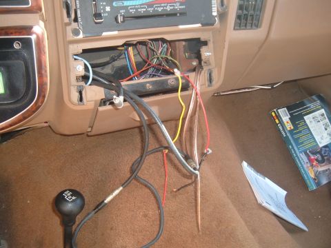 1988 Ford Bronco - The interior of an older vehicle shows exposed wiring and a manual transmission shifter.