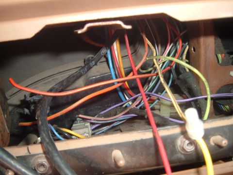 1988 Ford Bronco - A complex web of wires and connectors is visible within the dashboard of a vehicle.