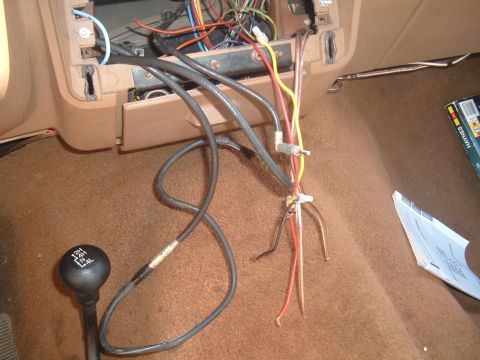 1988 Ford Bronco - The interior of a 1988 Ford Bronco reveals exposed wiring for the radio installation, alongside the 4x4 gear shifter.
