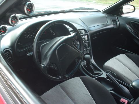1996 Ford Probe - The interior of a 1996 Ford Probe is visible, aftermarket gauges mounted above the dashboard.
