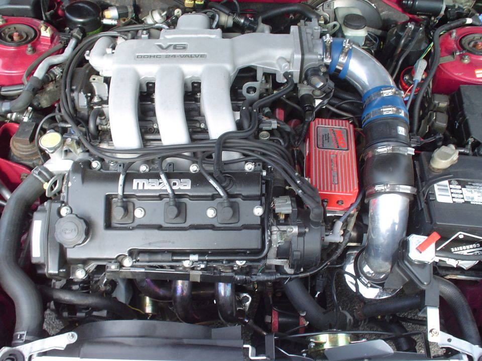 Mazda V6 DOHC 24-valve engine with red aftermarket ignition module