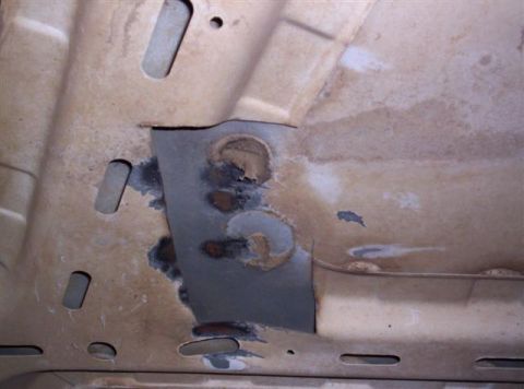 1995 Ford Bronco - This image shows underbody rust repair work, with a patch and several holes visible.