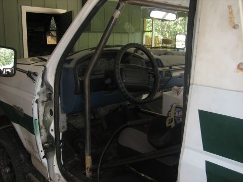 1994 Ford Bronco - Interior of a white truck, possibly a Ford F-series, with a roll cage installed.