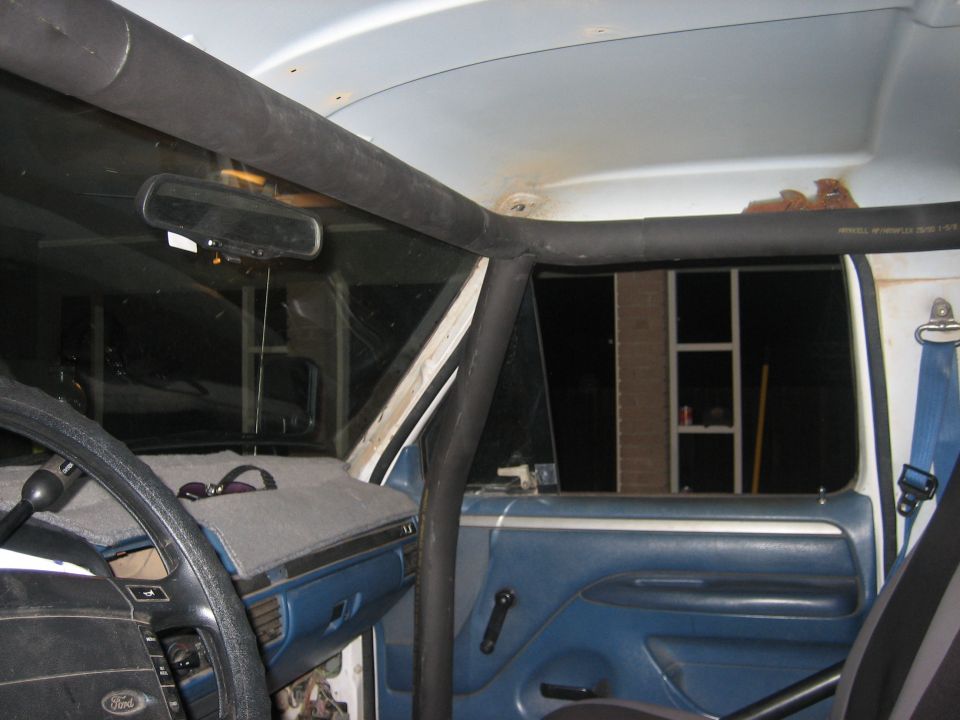 1994 Ford Bronco interior with roll cage and blue door panels