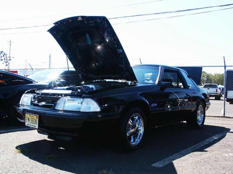 Black Fox body Mustang coupe with hood and trunk open, parked at a car show. New Jersey license plate FM-380N